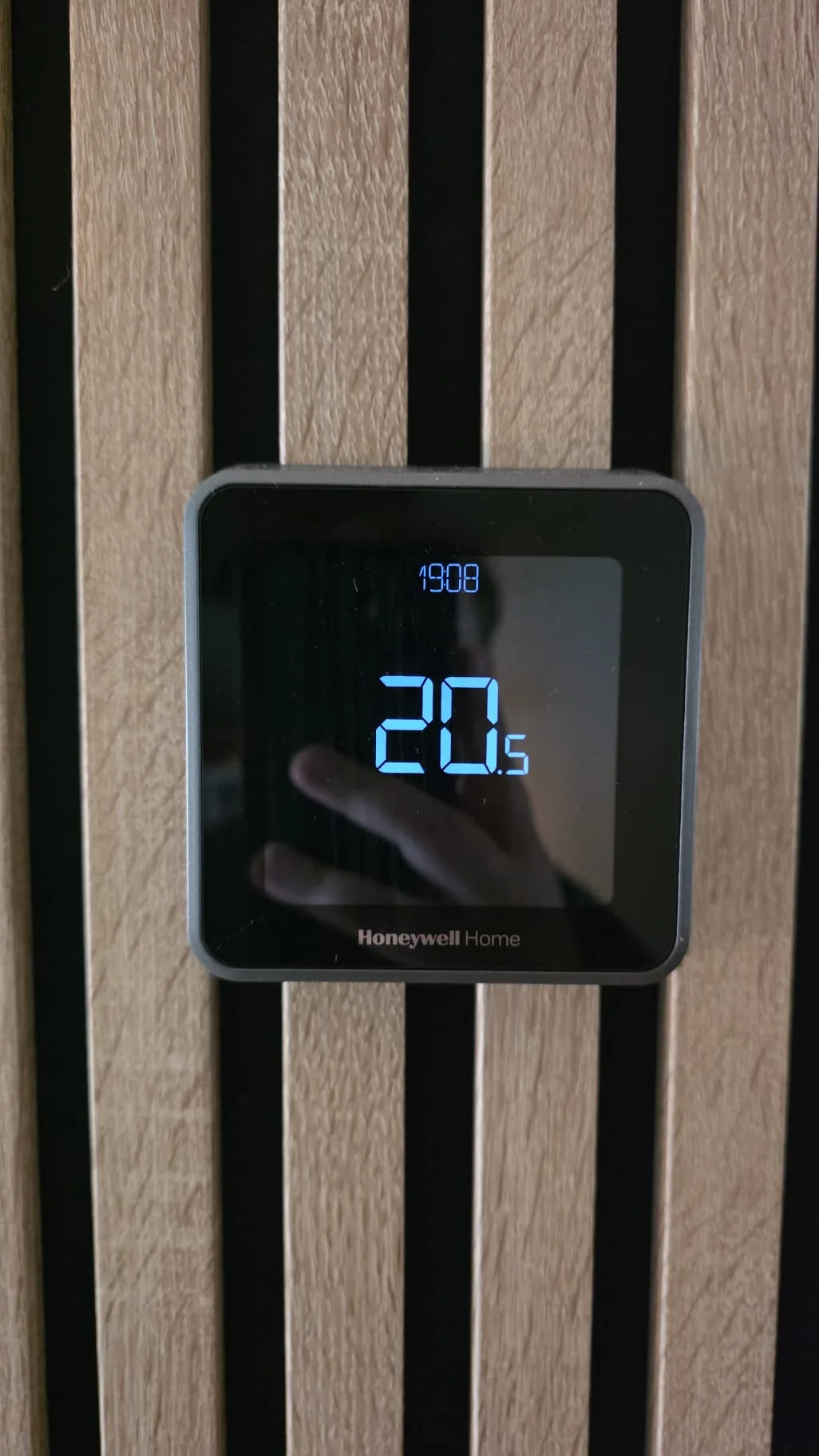Thermostaat op een wand met houten lamellen