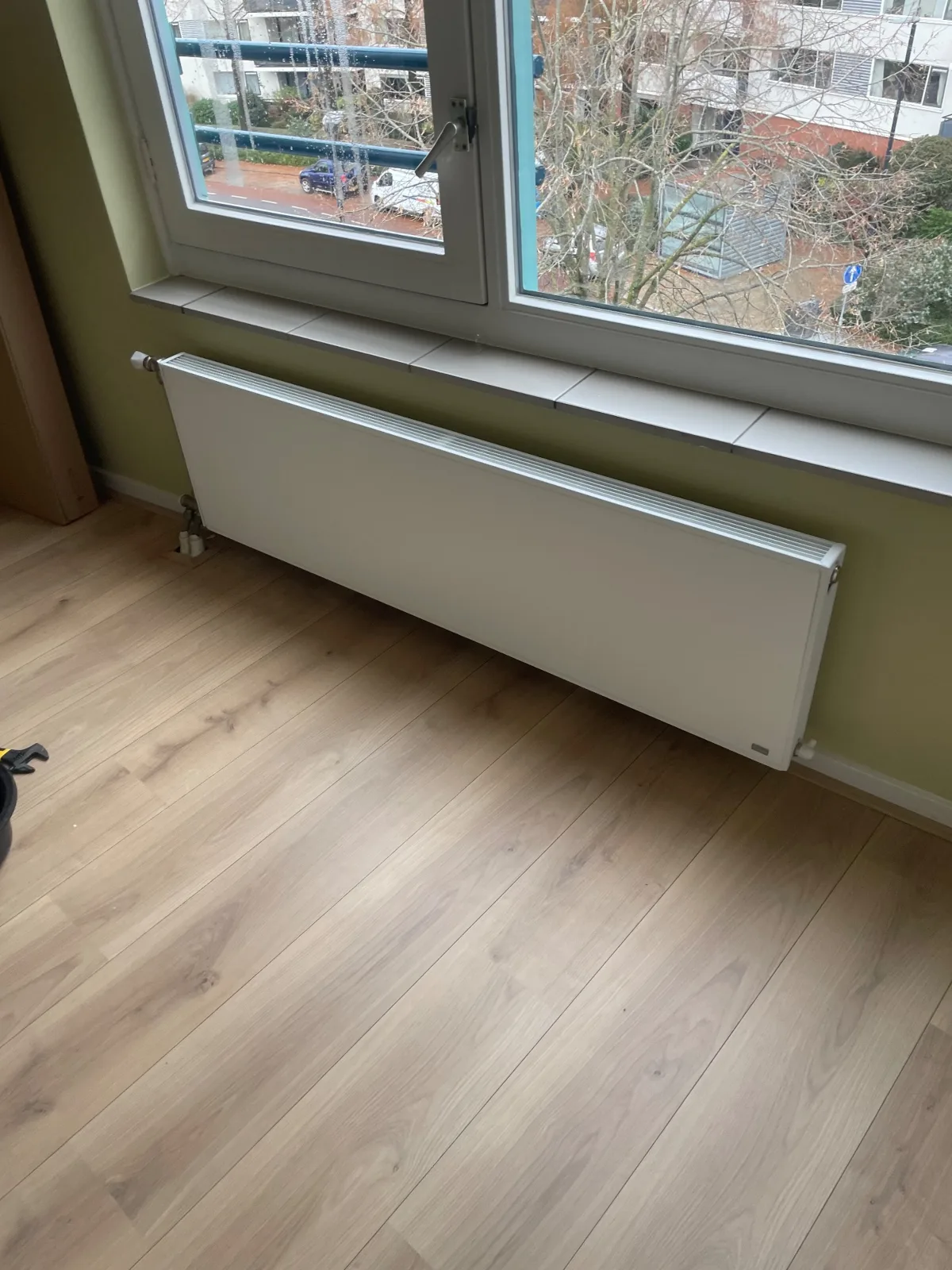 Witte radiator onder een raam